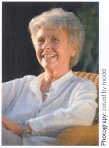 Photograph of an older woman relaxing in a chair and smiling