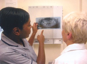 Photograph of two dental professionals viewing a dental x-ray at a lightbox