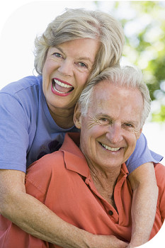 Photograph of elderly couple smiling for the camera and showing good teeth
