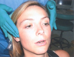 Photograph of a dentist examining a woman's jaw