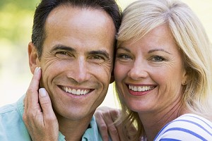 Photograph of a middle-aged couple smiling for the camera showing good teeth