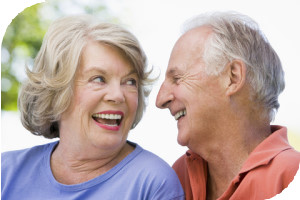 Photograph of an older couple smiling and showing heathy teeth and gums